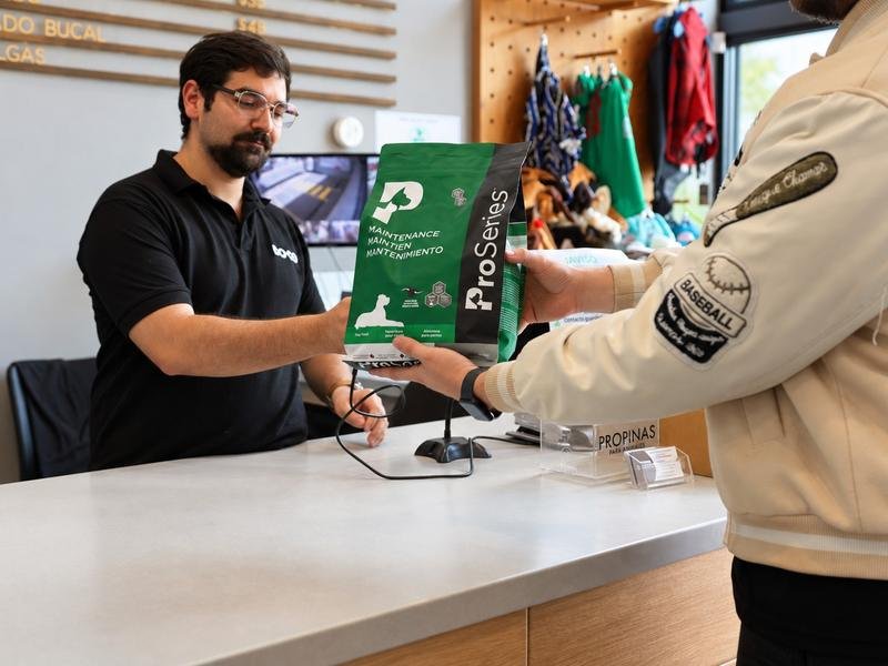Colaborador de DOGO entregando un alimento ProSeries a un cliente en el mostrador