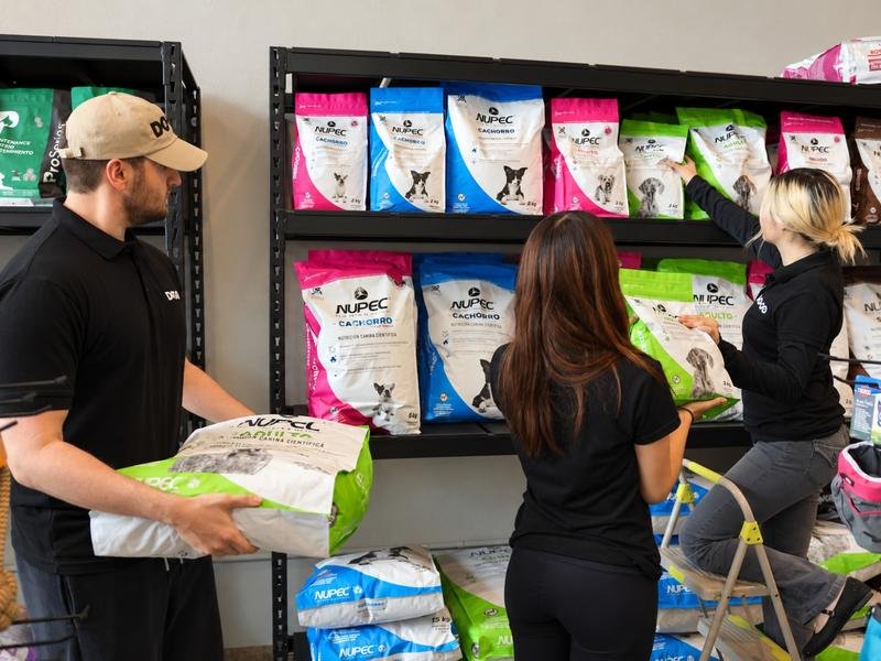 Equipo de DOGO surtiendo los anaqueles de alimento Nupec en la tienda